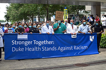 Photo of Radiology group holding a sign that says "Stronger Together: Duke Health Stands Against Racism"