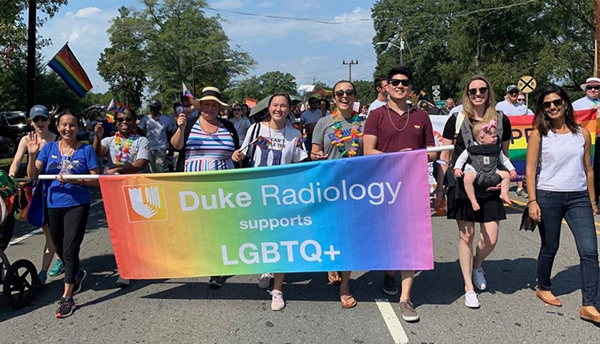 Photo of radiology group holding sign that says "Duke Radiology Supports LGBTQ+"