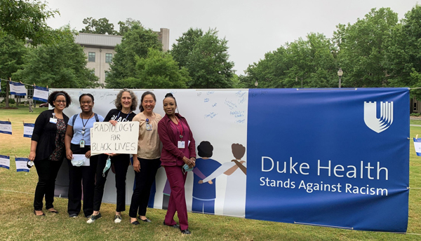 Photo of Radiology group standing in front of sign that says "Duke Health Stands Against Racism"