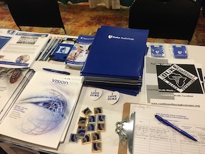 Booklets, sign-up sheet, and other materials on a table