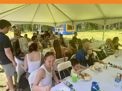 People at tables under a tent