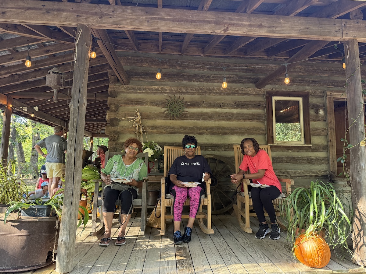 Three people sitting on a porch