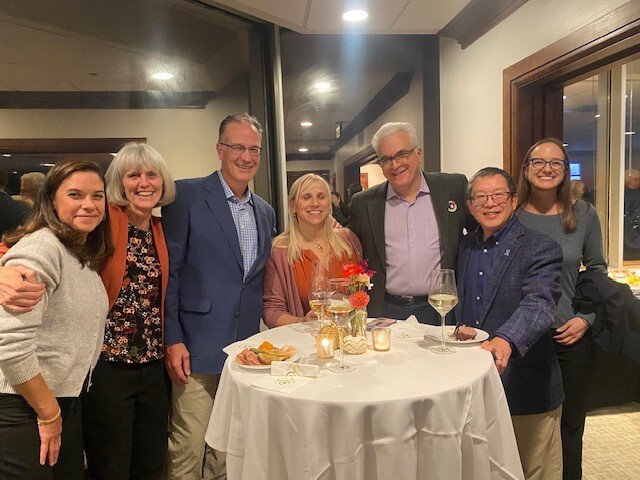 Group of people standing around a table at a party