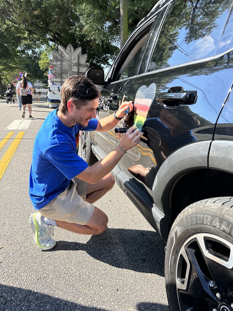Person putting a pride sticker on vehicle