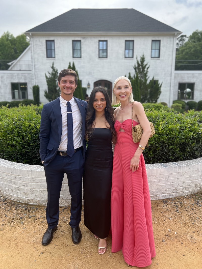 Three people in front of a house