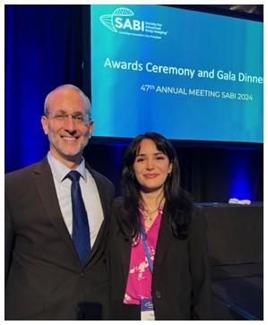 2 people standing in front of an awards ceremony sign
