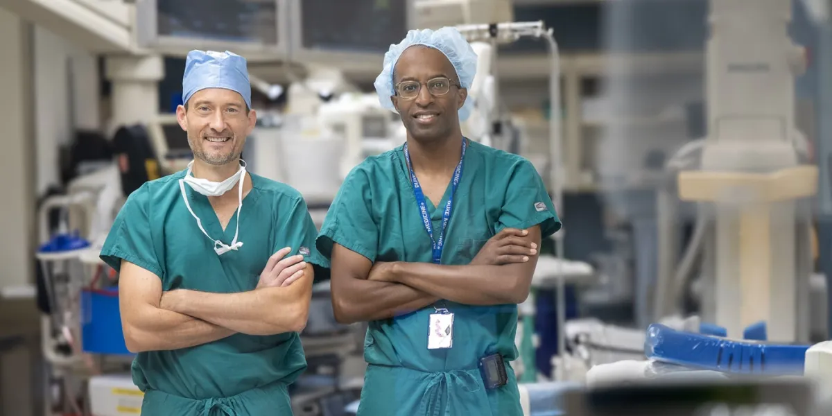 Interventional radiologist James Ronald, MD (left), and vascular surgeon Kevin Southerland, MD (right), stand in an operating room used for deep vein arterialization.