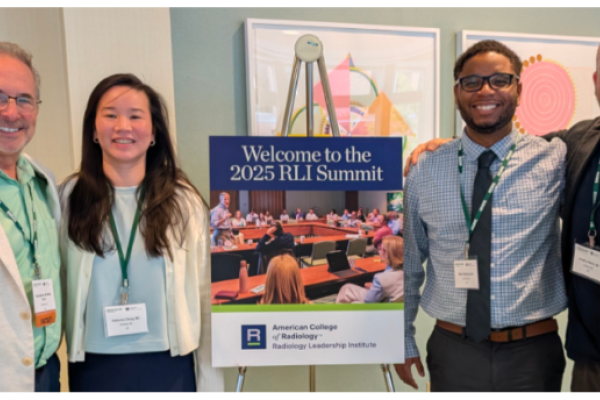 People standing next to a poster for RLI Summit