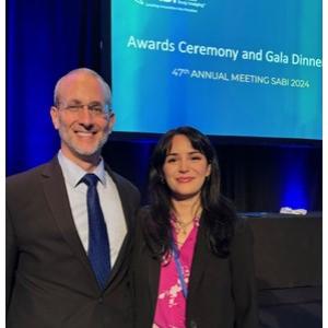 2 people standing in front of an awards ceremony sign